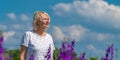 Outdoor portrait of a beautiful happy middle aged blonde woman in a field with flowers Royalty Free Stock Photo