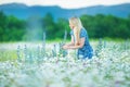 Outdoor portrait of a beautiful middle aged blonde woman. attractive girl in a field with flowers daises Royalty Free Stock Photo