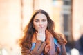 Outdoor portrait of beautiful redhead woman covering her mouth with hand Royalty Free Stock Photo