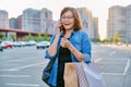 Outdoor portrait of a beautiful 40s woman talking on phone with shopping bags Royalty Free Stock Photo