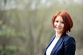 Outdoor portrait of beautiful woman with red hair