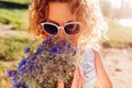 Outdoor portrait of beautiful young woman with red curly hair holding bouquet of flowers. Allergy free Royalty Free Stock Photo