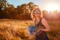 Outdoor portrait of beautiful young woman with red curly hair holding flowers. Summer mood. Royalty Free Stock Photo