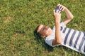 Outdoor portrait of blond boy teenager, male young man texting or using social media on cell phone on nature background Royalty Free Stock Photo