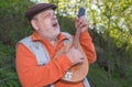 Outdoor portrait of Caucasian senior man playing mandolin while singing Royalty Free Stock Photo