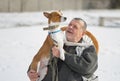 Portrait of Caucasian senior man taking his majestic basenji dog on the hands Royalty Free Stock Photo