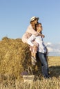 Outdoor portrait of couple in love sitting on hay bale Royalty Free Stock Photo