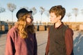 Outdoor portrait of a couple of young boy and girls looking at each other, smiling teenagers in the sunset light, golden hour Royalty Free Stock Photo