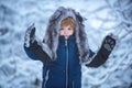 Outdoor portrait of cute baby kid in cold sunny winter weather in park. Little child in snow field. Winter portrait of