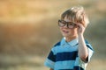 Outdoor portrait of a cute little 4 year old boy wearing eyeglasses. Smart little child go back to primary school Royalty Free Stock Photo