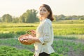 Outdoor portrait of farmer woman with basket of fresh chicken eggs, farm Royalty Free Stock Photo