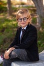 Outdoor portrait of Fashionable Schoolboy with glasses, school uniform, blonde boy with long hair Royalty Free Stock Photo