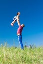 Outdoor portrait of a father who throws daughter on hands against the sky