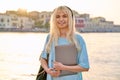 Outdoor portrait of female student teenager in headphones with backpack and laptop Royalty Free Stock Photo