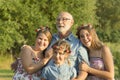 Outdoor portrait of grandfather with granddaughters.