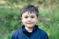 Outdoor portrait hamdsome young boy looking at camera with smiling face, Healthy kid with a happy face standing alone in the park Royalty Free Stock Photo