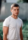 Outdoor portrait of a handsome young man in jeans and gray t-shirt. Royalty Free Stock Photo