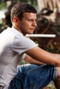 Outdoor portrait of a handsome young man in jeans and gray t-shirt. Royalty Free Stock Photo