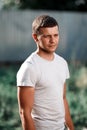 Outdoor portrait of a handsome young man in jeans and gray t-shirt. Royalty Free Stock Photo