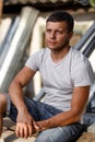 Outdoor portrait of a handsome young man in jeans and gray t-shirt. Royalty Free Stock Photo