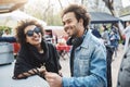 Outdoor portrait of happy african-american couple with afro hairstyles, leaning on table while on food festival Royalty Free Stock Photo