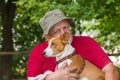 Portrait of happy basenji dog in the hands of its bearded master