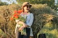 Outdoor portrait of happy mature woman with a bouquet of poppies red flowers