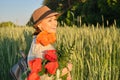 Outdoor portrait of a happy mature woman with bouquets of red poppies flowers