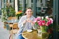 Portrait of happy middle age woman relaxing in outdoor cafe, holding cup of coffee Royalty Free Stock Photo