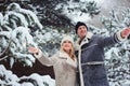 Outdoor portrait of happy romantic couple celebrating Christmas with burning fireworks in snowy forest Royalty Free Stock Photo