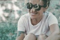 Outdoor portrait of happy serene mid adult woman smiling and enjoying outdoor leisure activity and relaxation. Wearing sunglasses