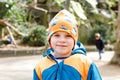 Outdoor portrait of little kid boy in spring or autumn colorful clothes. Happy boy having fun in a zoo. Smiling child Royalty Free Stock Photo