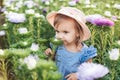 Outdoor portrait. Little toddler lovely girl with flowers at beautiful garden. child outdoors in nature