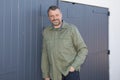 Outdoor portrait of middle aged white man front garage wooden grey door Royalty Free Stock Photo