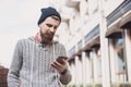 Outdoor portrait of modern young traveler man using smart phone on the street Royalty Free Stock Photo