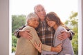 Outdoor, portrait and old man hug family on patio of home, smile and happiness from wife and daughter. House, adult and Royalty Free Stock Photo