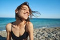 Outdoor portrait pleased woman enjoying sunshine at sea beach against blue sky