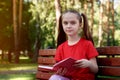 Outdoor portrait of pretty little  girl reading book Royalty Free Stock Photo