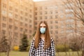 Outdoor portrait of sad young woman wearing protective mask on street. Concept of health and safety life covid19 coronavirus Royalty Free Stock Photo