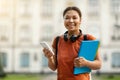 Outdoor Portrait Of Smiling Black Female Student With Smartphone And Workbooks Royalty Free Stock Photo