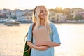 Outdoor portrait of female student teenager in headphones with backpack and laptop Royalty Free Stock Photo
