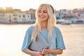 Outdoor portrait of female student teenager in headphones with backpack and laptop Royalty Free Stock Photo