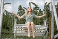 Outdoor portrait of a smiling happy girl. Fashion woman on wooden bench. Beauty blonde girl relaxing outdoors on porch Royalty Free Stock Photo