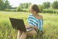 Outdoor portrait smiling middle-aged woman freelancer blogger traveler with laptop on nature Royalty Free Stock Photo