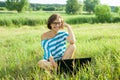 Outdoor portrait smiling middle-aged woman freelancer blogger traveler with laptop on nature Royalty Free Stock Photo