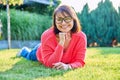 Outdoor portrait of smiling middle aged woman lying on grass Royalty Free Stock Photo