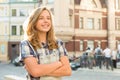 Outdoor portrait of smiling teenager girl 12, 13 years old on city street, girl with folded hands, copy space Royalty Free Stock Photo