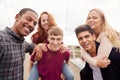 Outdoor Portrait Of Student Friends With Men Giving Women Piggyback Rides