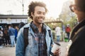 Outdoor portrait of stylish upbeat african-american male with bristle and afro hairstyle holding cup of coffee and Royalty Free Stock Photo
