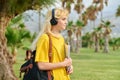 Outdoor portrait of teenage female student in headphones with laptop backpack Royalty Free Stock Photo